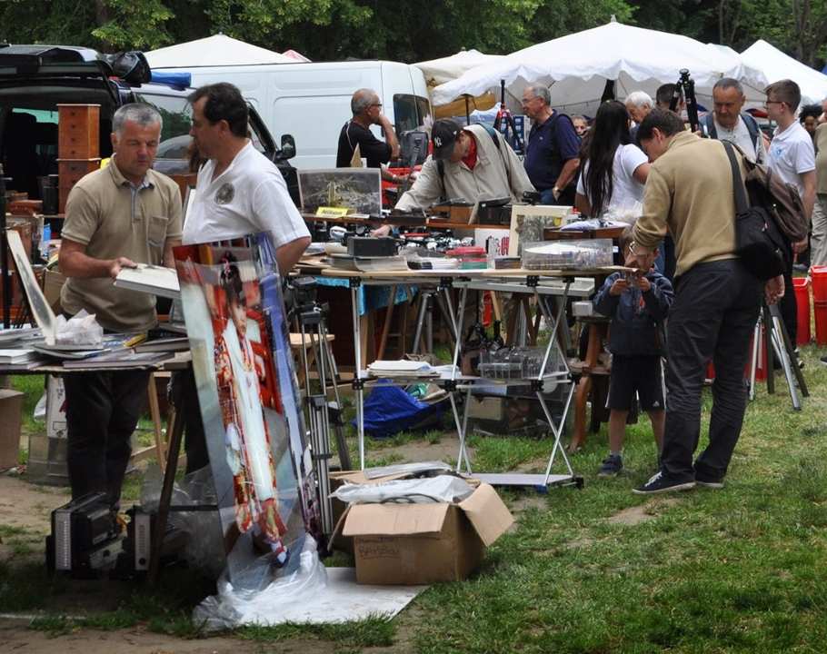 Marché de la photographie en plein air avec exposants, visiteurs et matériel photo vintage exposé sur les stands.