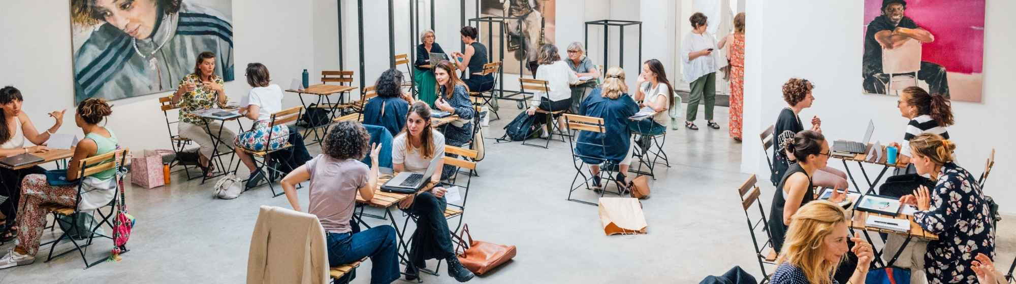 Plusieurs groupes travaillant dans un atelier photo dans une grande salle