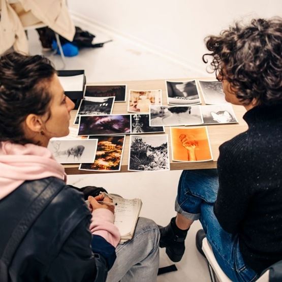 Deux personnes analysant des tirages photo sur une table