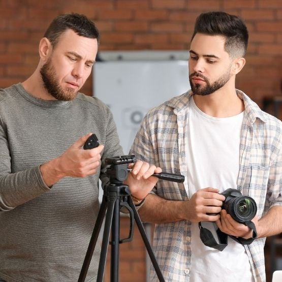Deux hommes apprenant à utiliser un trépied et un appareil photo