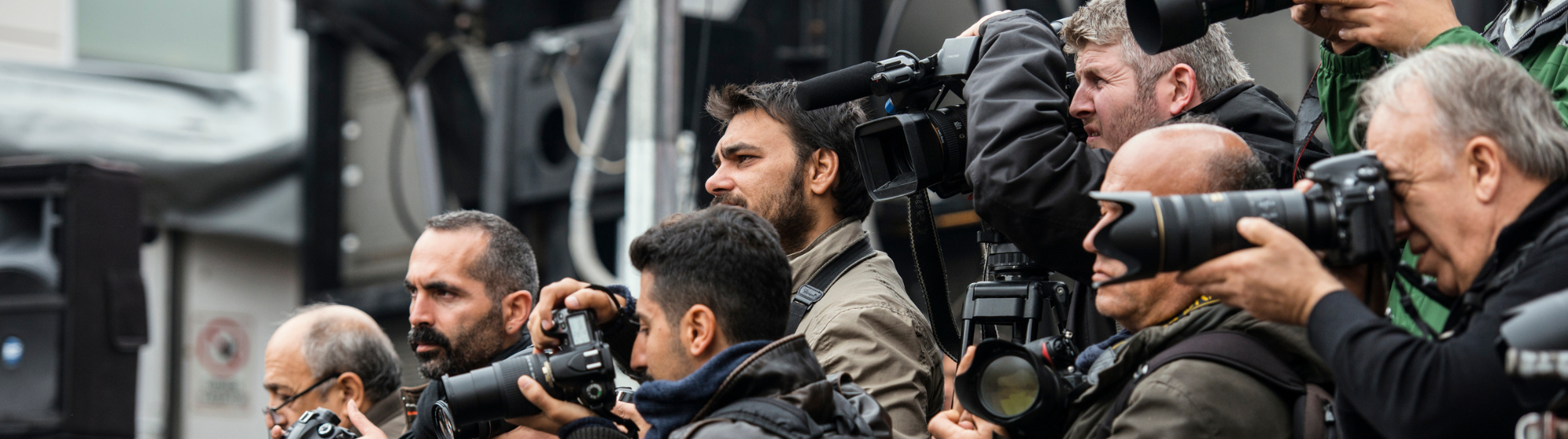 Groupe de photographes professionnels prenant des clichés avec des appareils photo équipés de téléobjectifs.