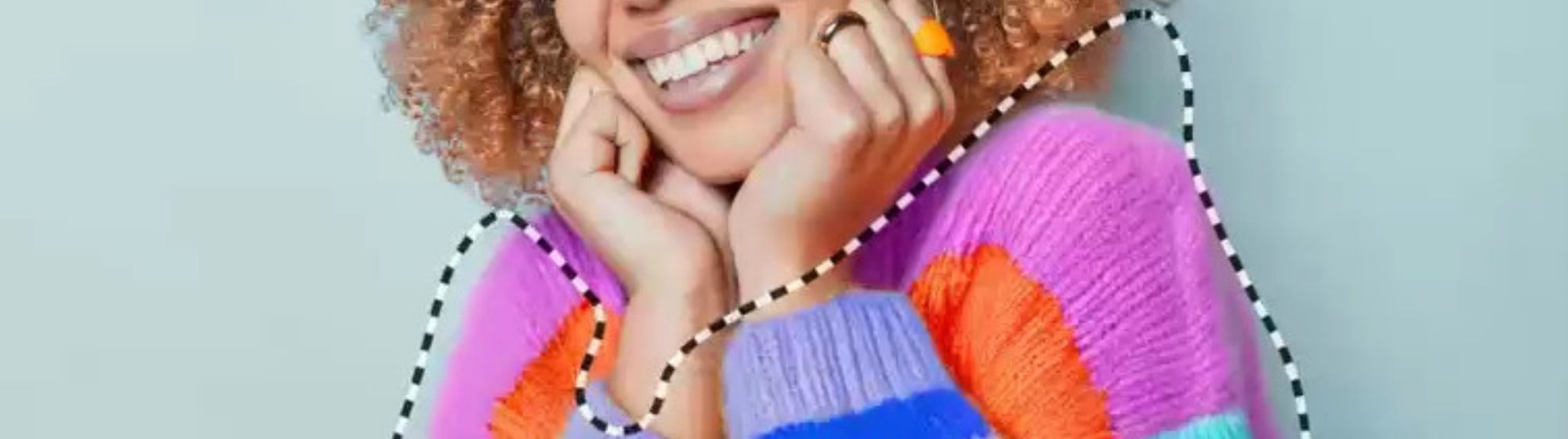Femme souriante portant un pull coloré, entourée d’un contour en pointillés illustrant une retouche photo assistée par intelligence artificielle.