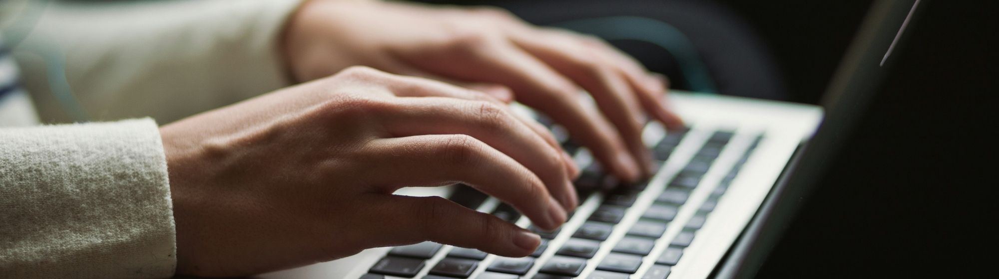 Main tapant sur le clavier d'un ordinateur portable dans un environnement détendu