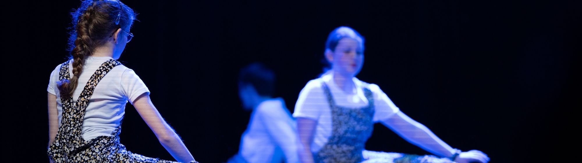 Jeunes danseuses en pleine chorégraphie sur scène, avec un effet de distorsion rolling shutter visible sur les lignes de l’image.
