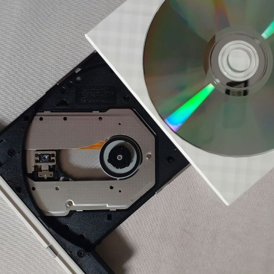 Lecteur optique d’ordinateur ouvert avec un disque CD partiellement inséré.