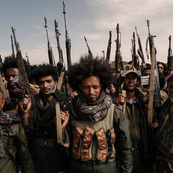 Photographie documentaire montrant un groupe d’hommes armés dans un reportage photo de type Magnum