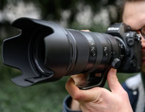 Photographe tenant un appareil Nikon Z avec objectif Nikkor Z 70-200mm