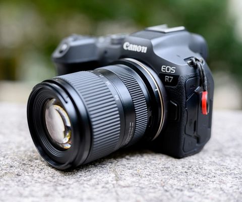 Appareil photo hybride Canon EOS R7 équipé d'un objectif, photographié en gros plan.