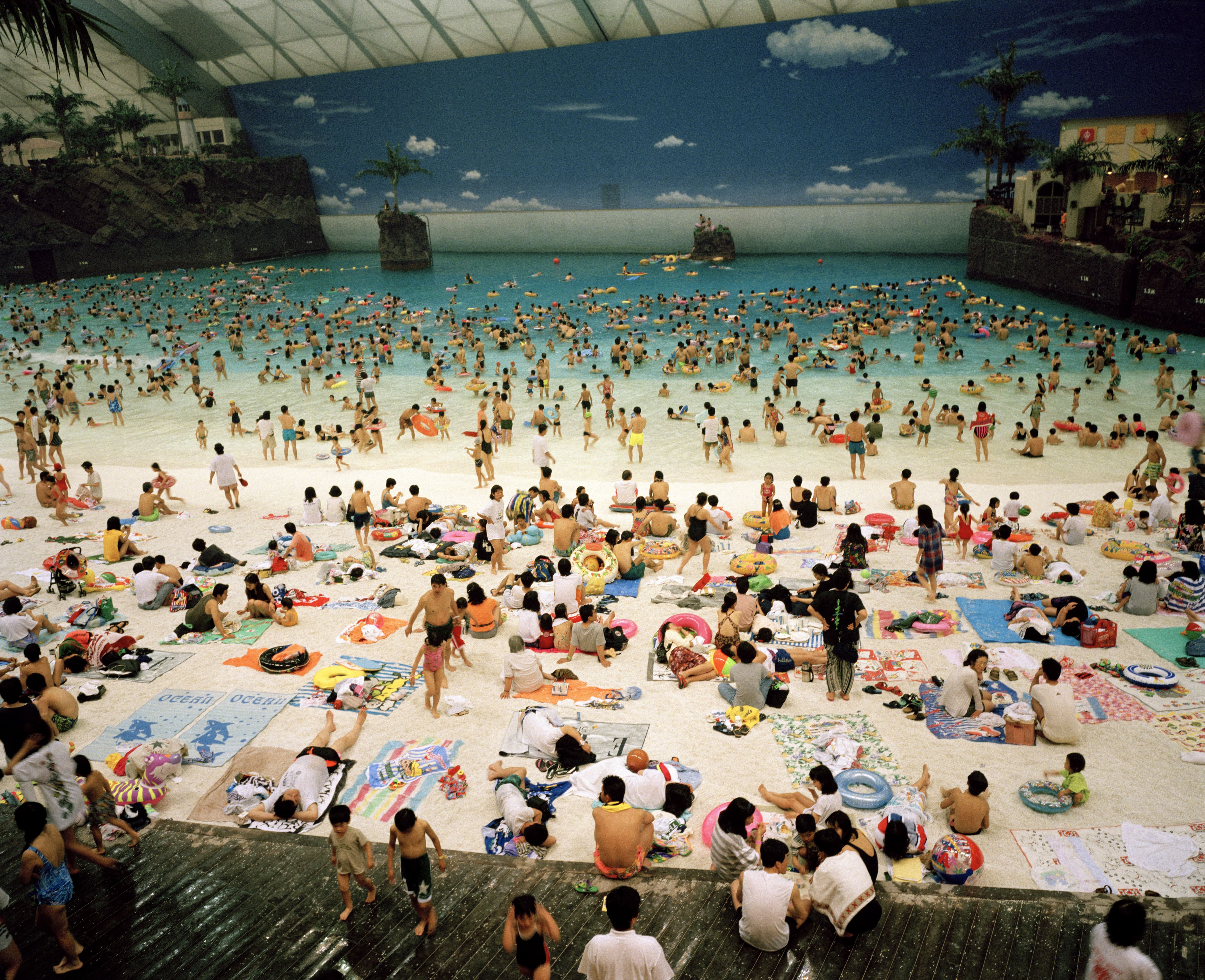 Vue d'une plage intérieure remplie de baigneurs et de personnes étendues sur des serviettes.