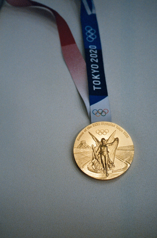 Photographie d'une médaille d'or sculptée représentant un ange humanoïde ailé sur une route pour les Jeux olympiques de 2020 à Tokyo