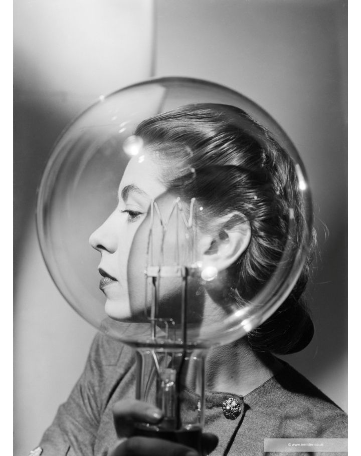 Portrait en noir et blanc d’une femme observée à travers une sphère en verre
