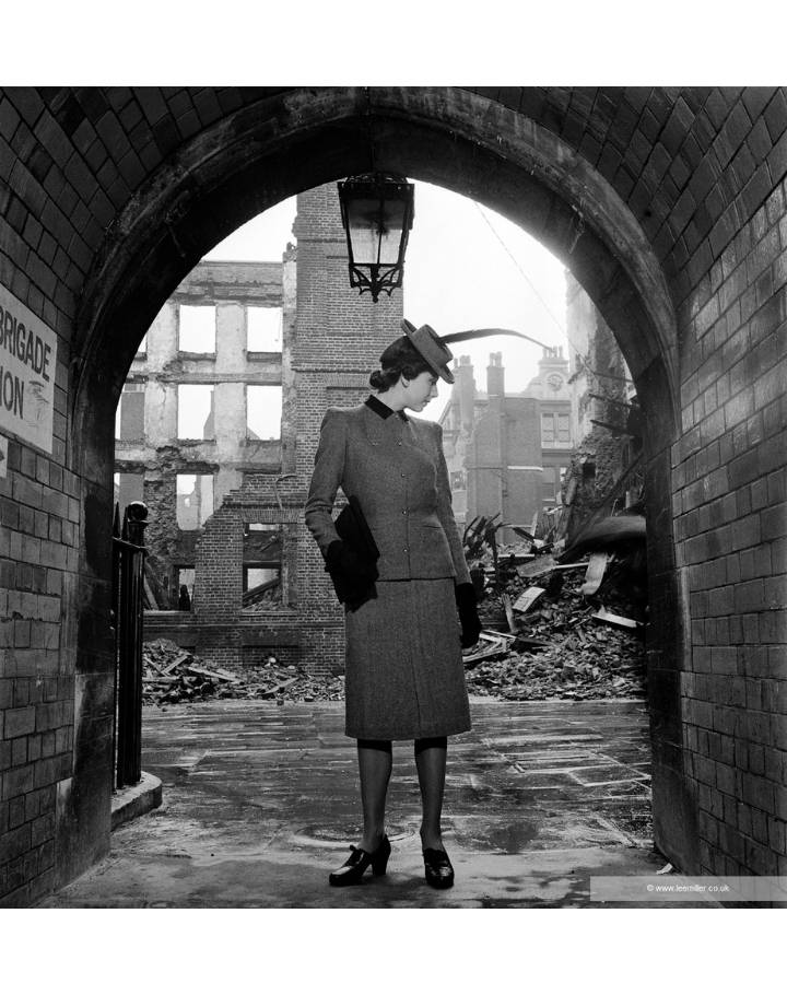 Femme élégante posant sous une arche au milieu de ruines urbaines dans une photographie en noir et blanc