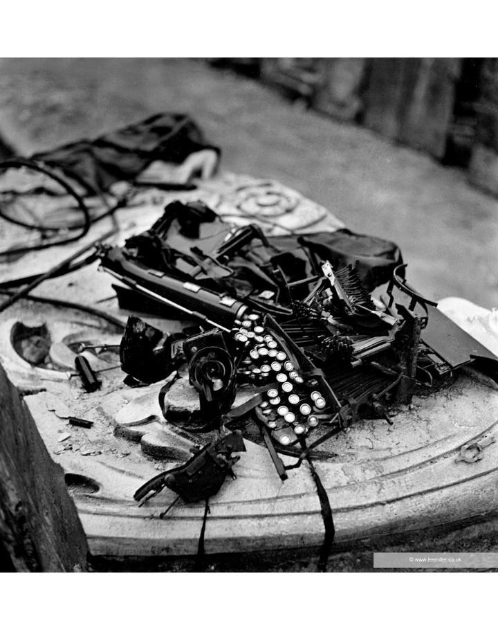 Machine à écrire endommagée photographiée en noir et blanc sur une surface poussiéreuse