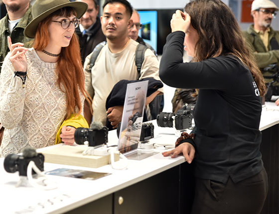Une femme discutant avec une exposante au Salon de la Photo