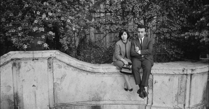 Photographie d'un couple assis sur un muret