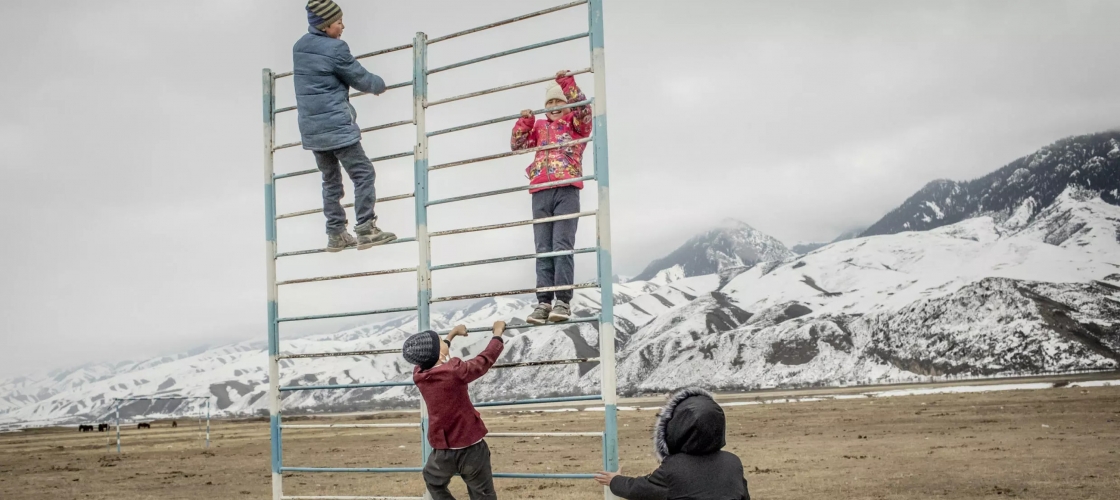 Enfants jouant à l'escalade avec des montagnes en arrière plan
